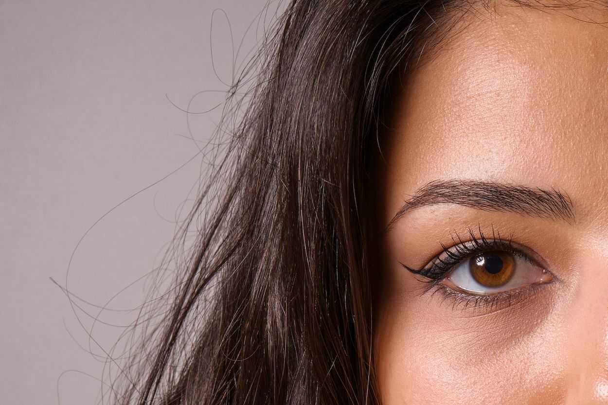Close-up of a woman's eye and eyebrow, highlighting makeup.