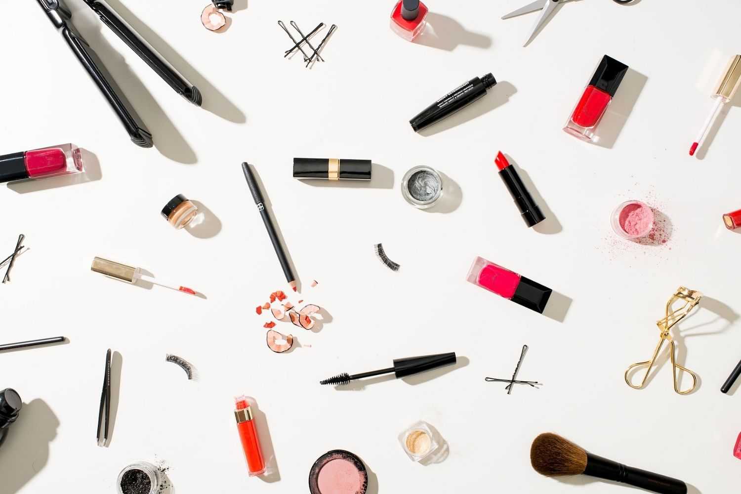 Assorted makeup products scattered on a white background.