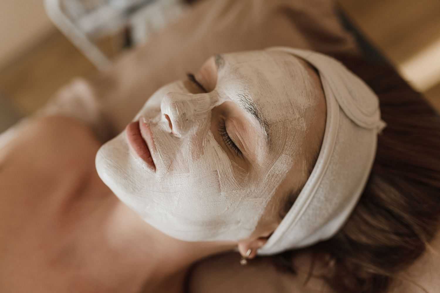 Woman relaxing with a face mask at a spa.